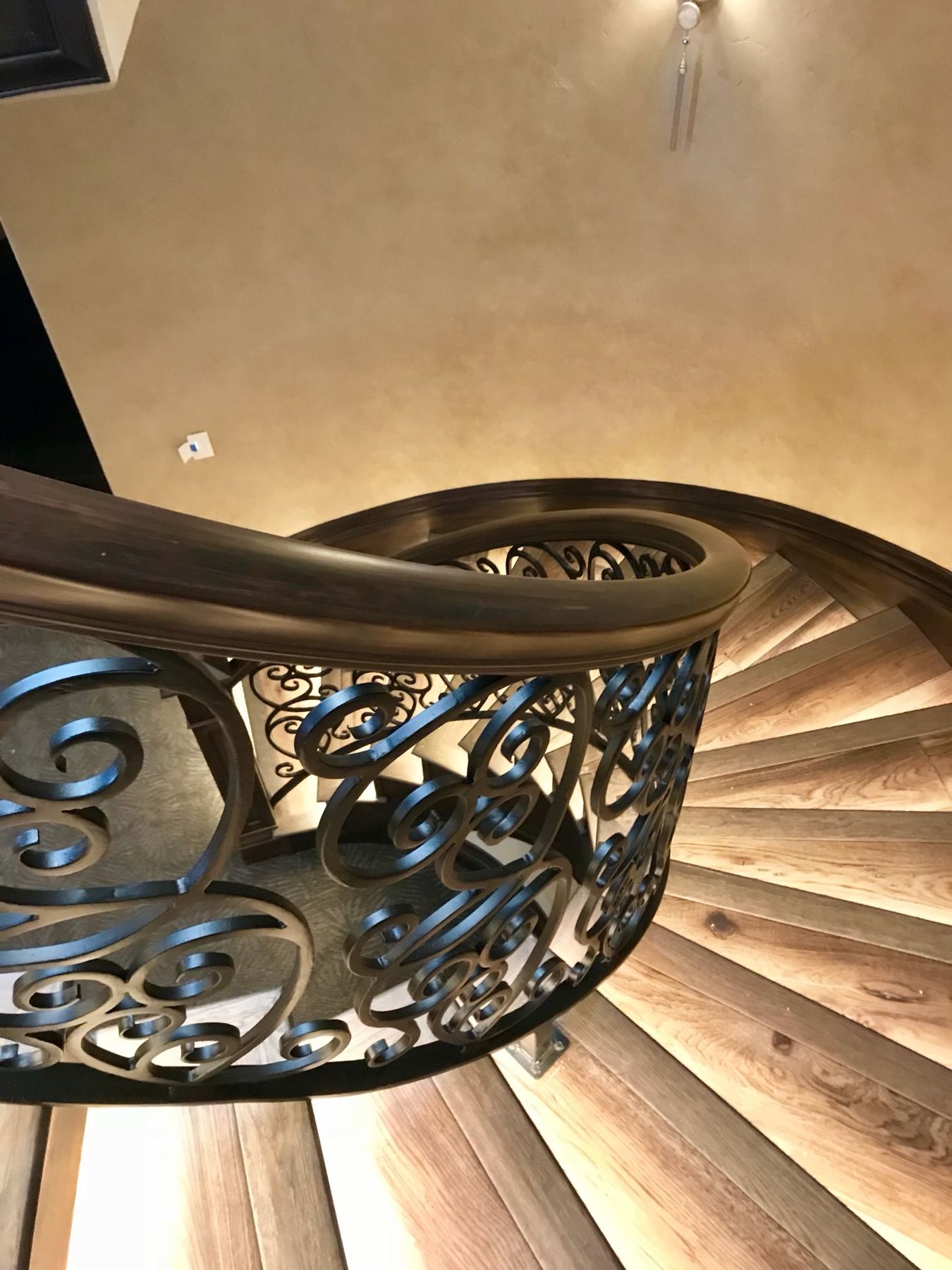 Curved staircase with iron balusters, looking down